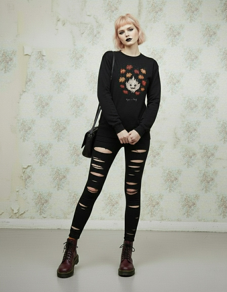 Person wearing a black outfit with a floral design, standing against a decorative wall.