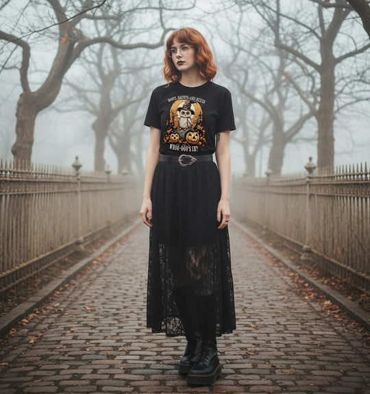 Person wearing a black t-shirt with graphic design and a long black skirt in a foggy park.