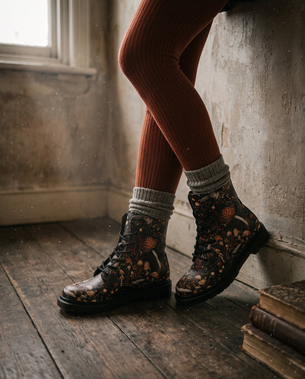 Legs in rust ribbed tights and grey socks wearing Toadstool Harvest Boots on old floorboards